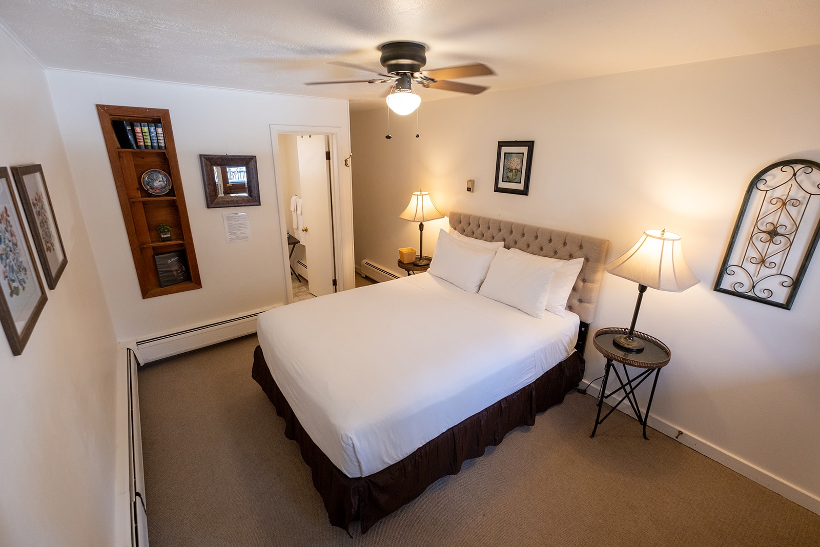 Cozy bedroom featuring a queen bed, bedside tables, and warm lighting.